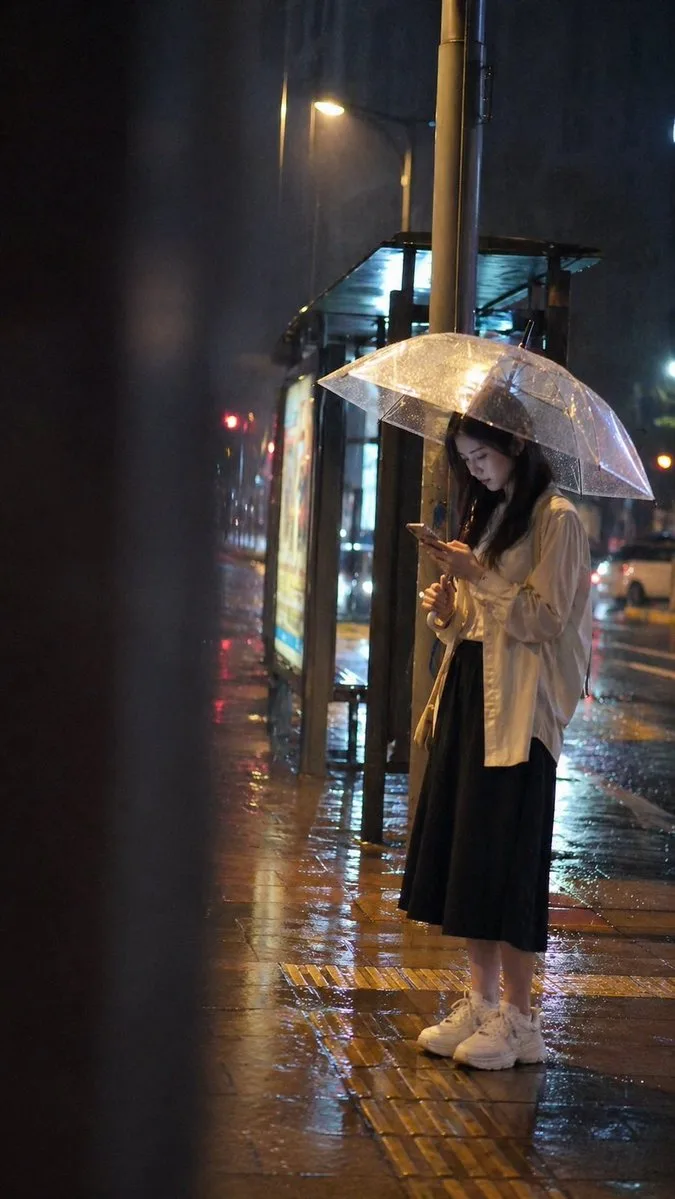 Rainy night bus stop girl — Sonra