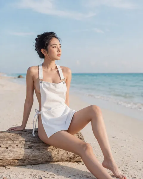 Chinese woman white denim apron beach driftwood