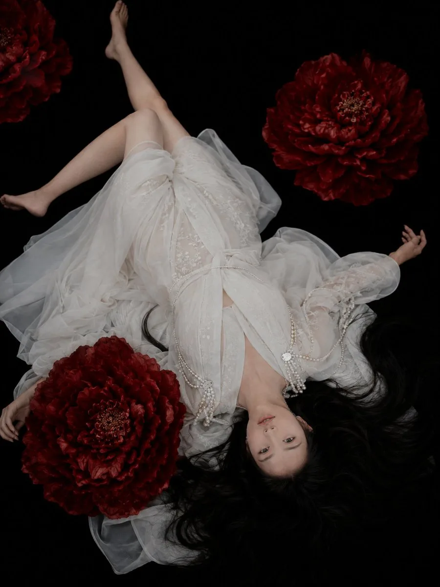Overhead oriental classical fashion portrait white dress red flowers — After