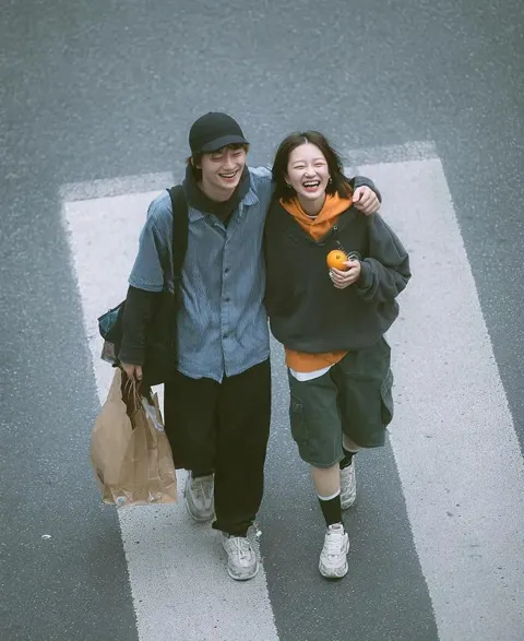 Cinematic overhead street photo young couple zebra crossing