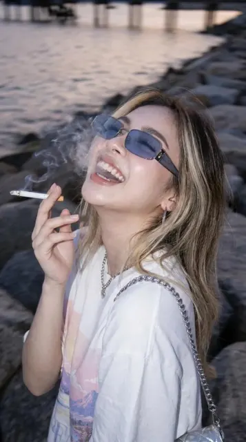 Stylish woman laughing coastal blue hour flash