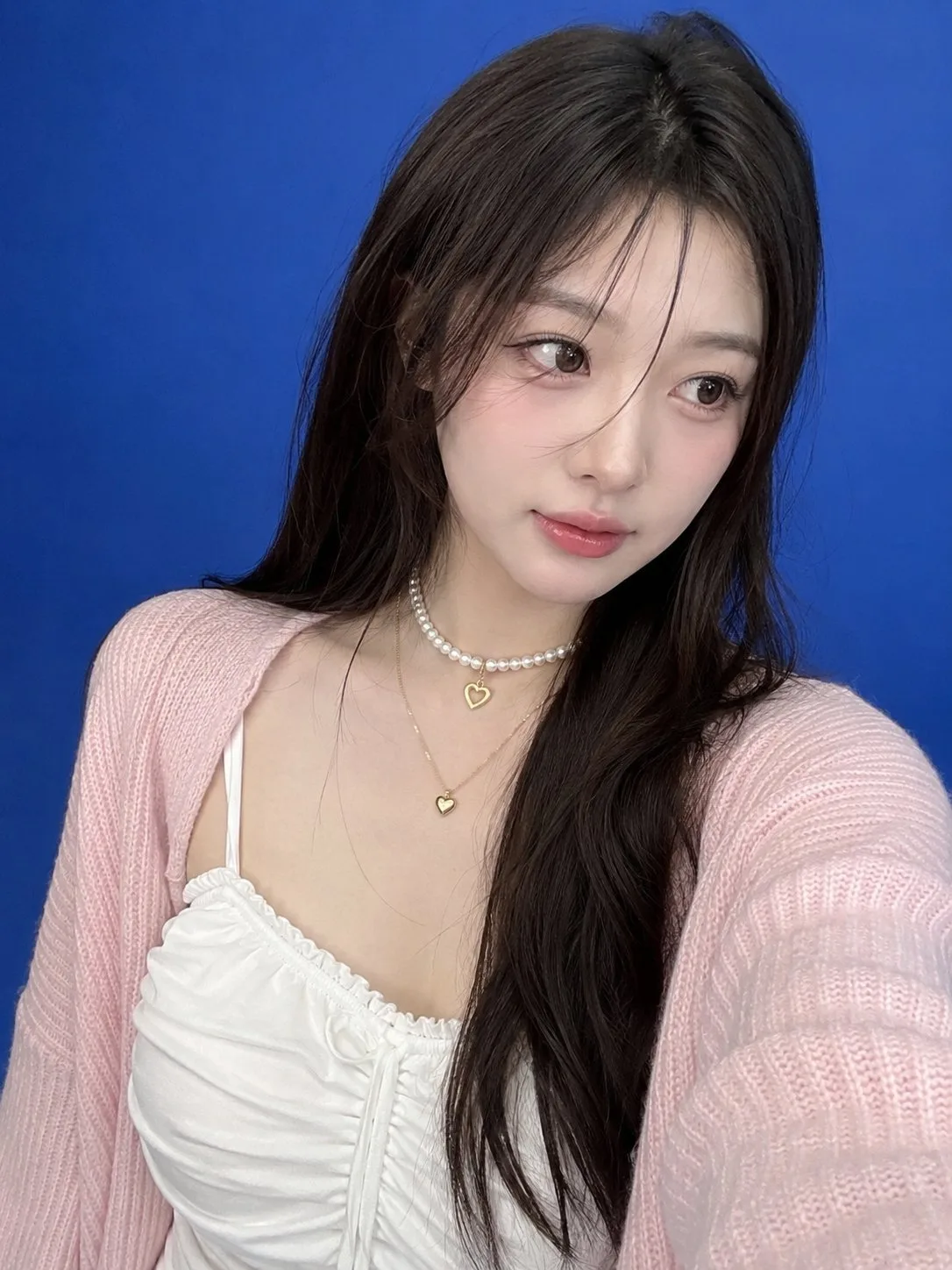 Ultra realistic smartphone selfie east asian woman blue backdrop — After