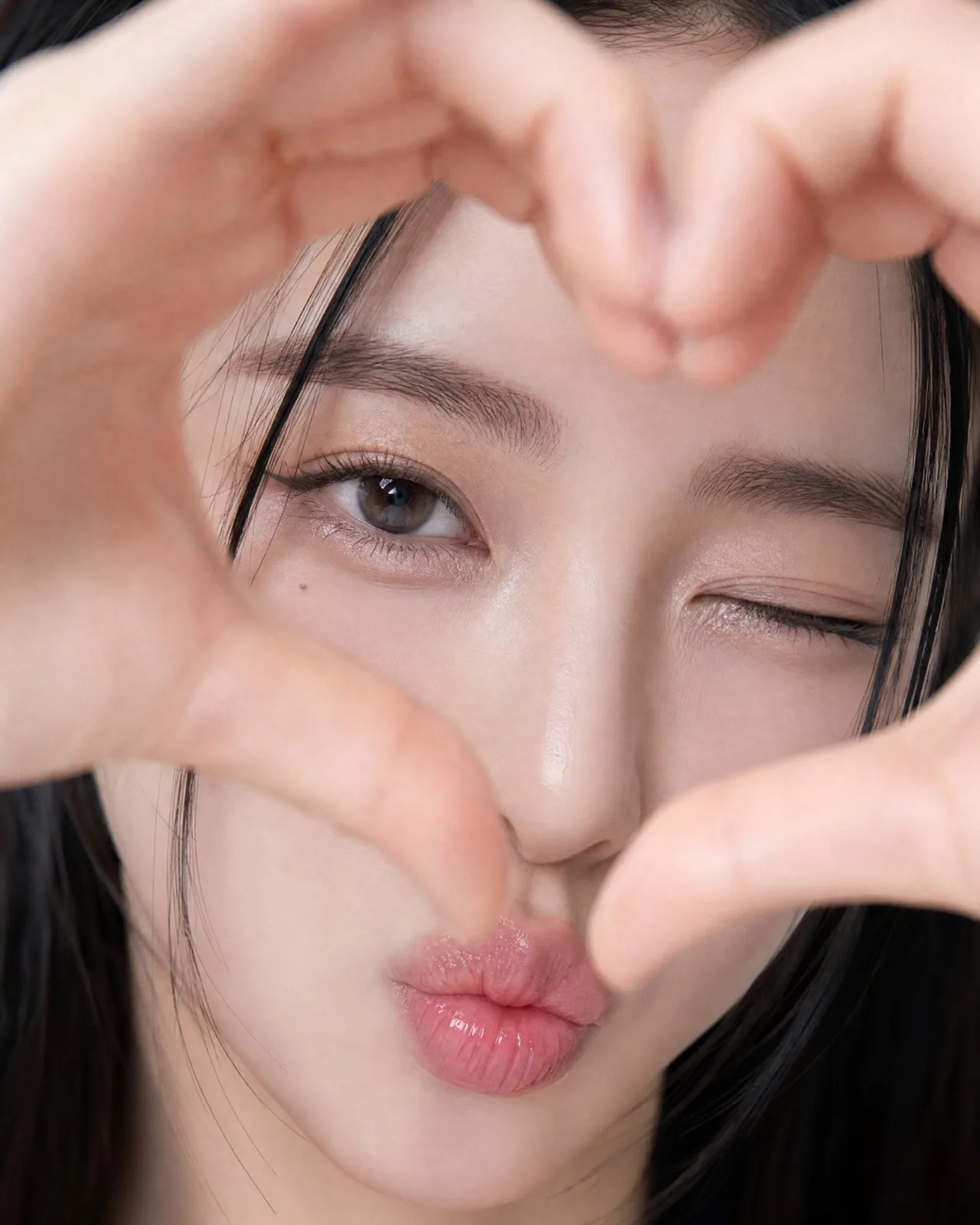 Extreme close up east asian woman heart gesture portrait — After