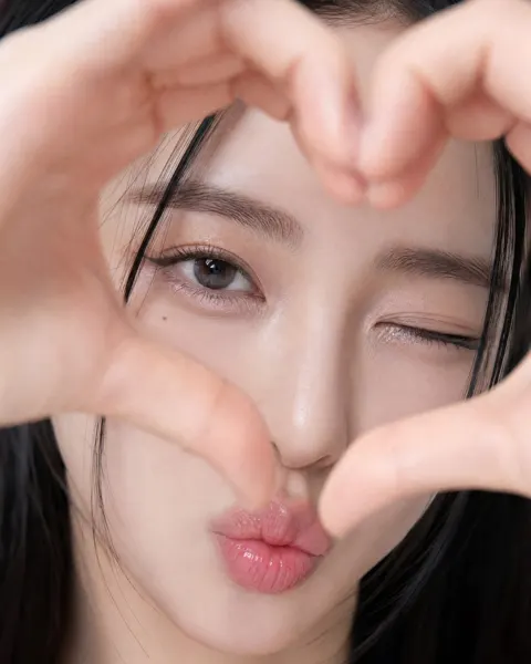 Extreme close up east asian woman heart gesture portrait