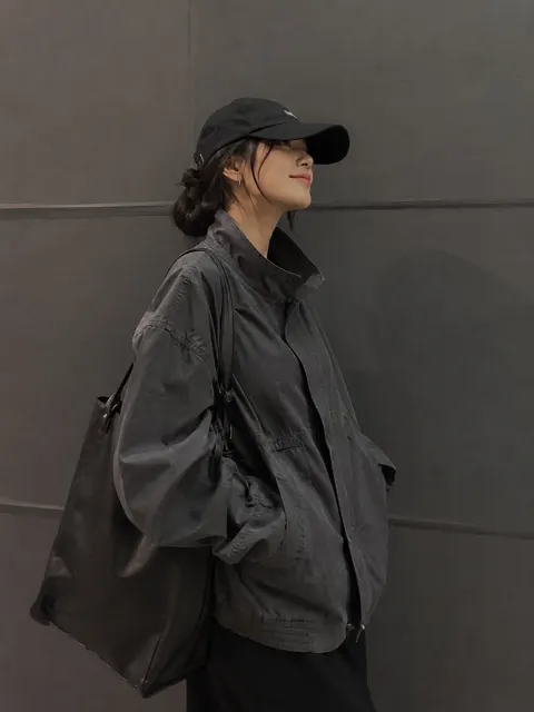 Stylish woman minimalist gray wall streetwear utility jacket