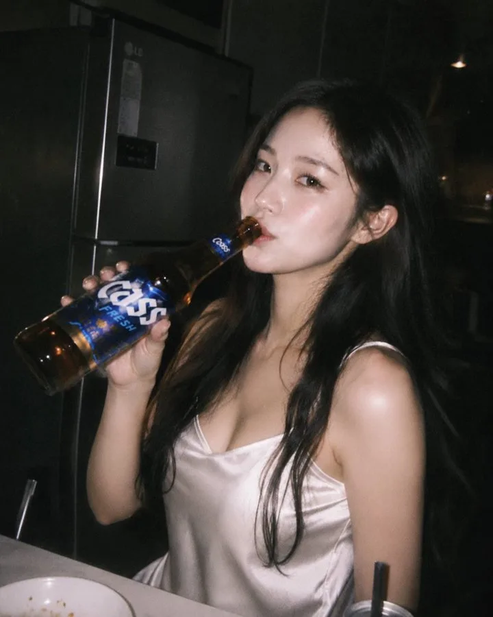 Korean style candid shotof beauty with beer in night kitchen — After