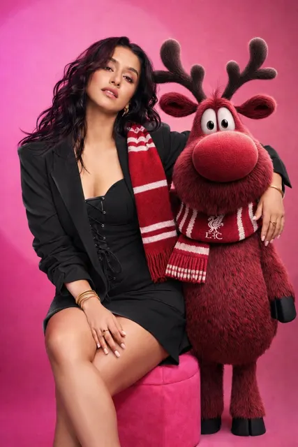 Pink blazer woman and anthropomorphic reindeer studio portrait