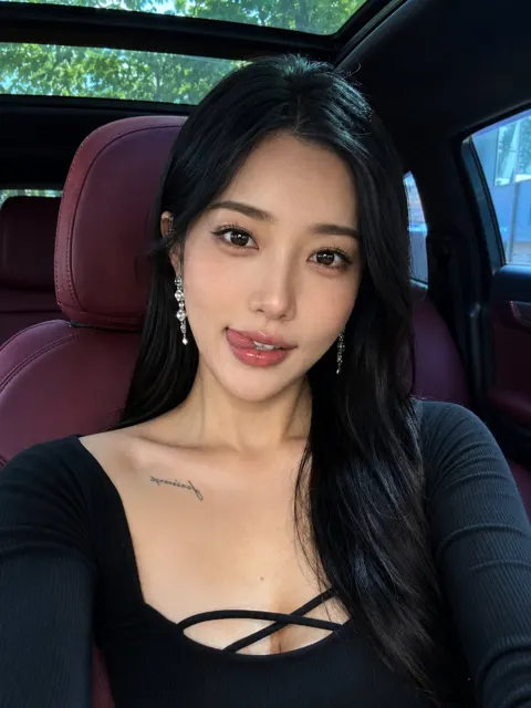 Elegant east asian woman luxury car playful selfie