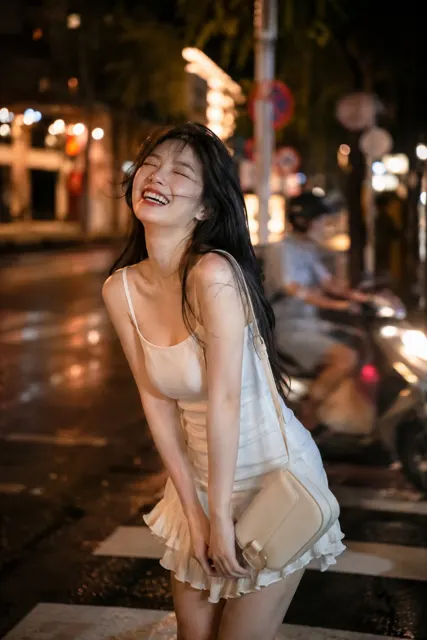 East asian woman white mini dress night city street