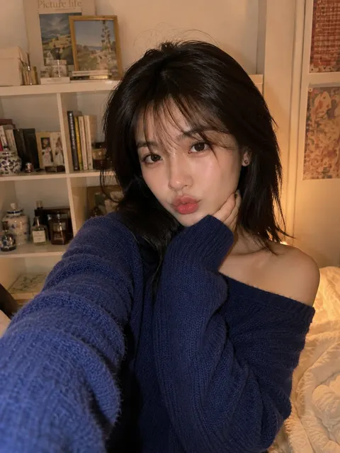 East asian woman smartphone selfie cozy bedroom